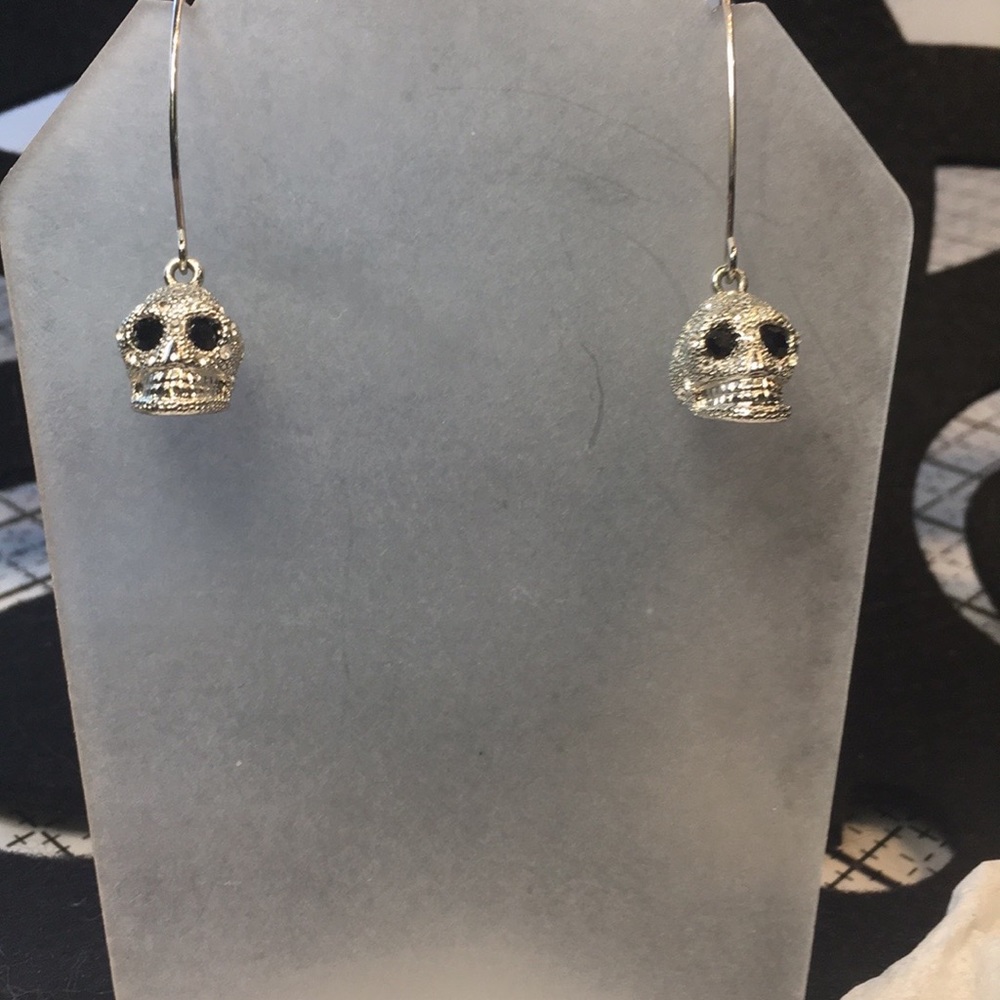 Rhinestone encrusted skull, black crystals eyes on long silver hook earrings.